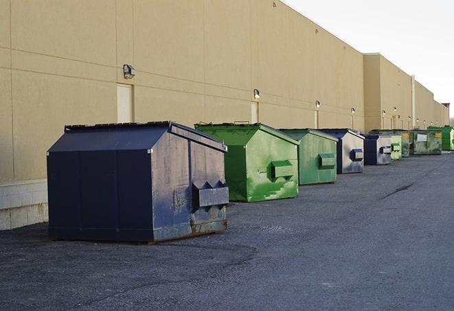 tilted front-load dumpsters being emptied by waste management workers in Addison, IL